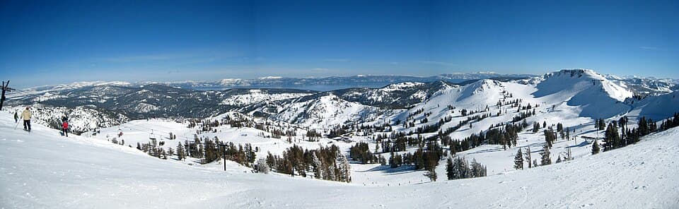 Sweeping summit panorama over the whole Palisades Tahoe bowl in mid-winter, lift lines and runs threading the basin with Washeshu Peak on the right.